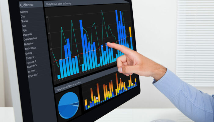 Cropped image of businessman analyzing graphs on computer in office