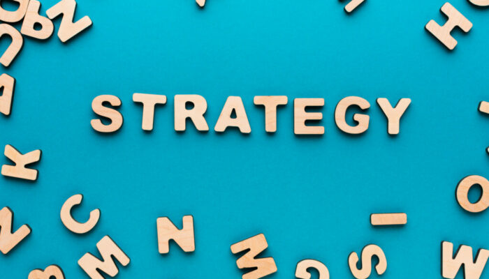 Word Strategy on blue background in wooden letters frame. Business plan, mission concept