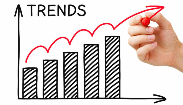 Male hand drawing Trends Growth Graph with marker on transparent wipe board.